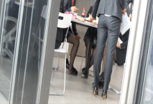 Lunch time hostess's black nylon feet under the table