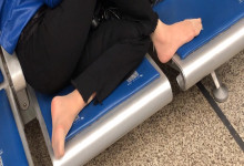 The lady remove shoes relax her tired feet when waitting for a train 54