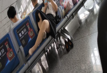 The middle-age lady relax her tired feet when waiting for a train