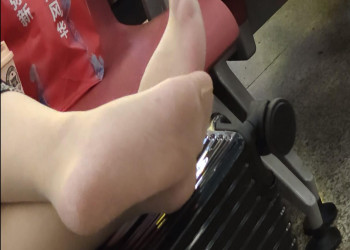 The lady relax her tired feet when waiting for a train