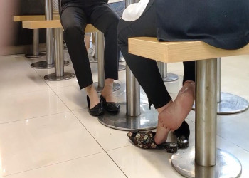 The lunch time they dipping shoeplay under the table