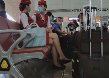 The airline stewardess dangling shoeplay in the terminal waiting hall