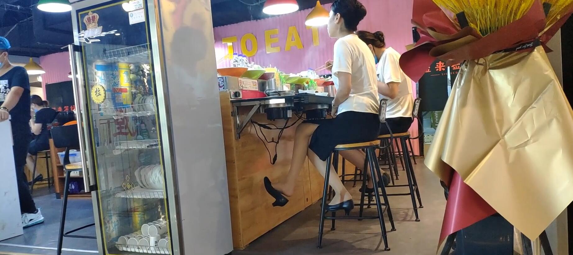 The lady dangling shoeplay under the table when having lunch 17