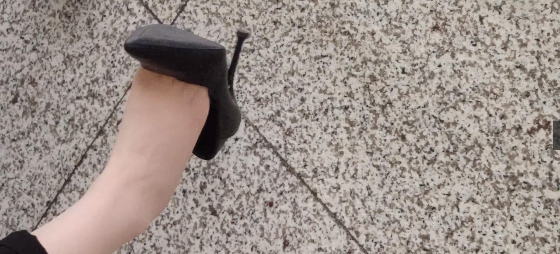 The middle-age lady dangling shoeplay  when waiting for a train