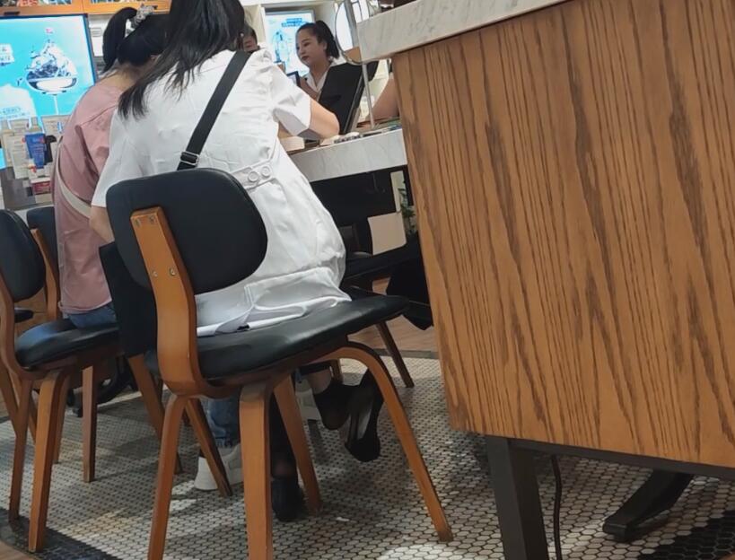 The girl in black nylon dangling under the table when having lunch