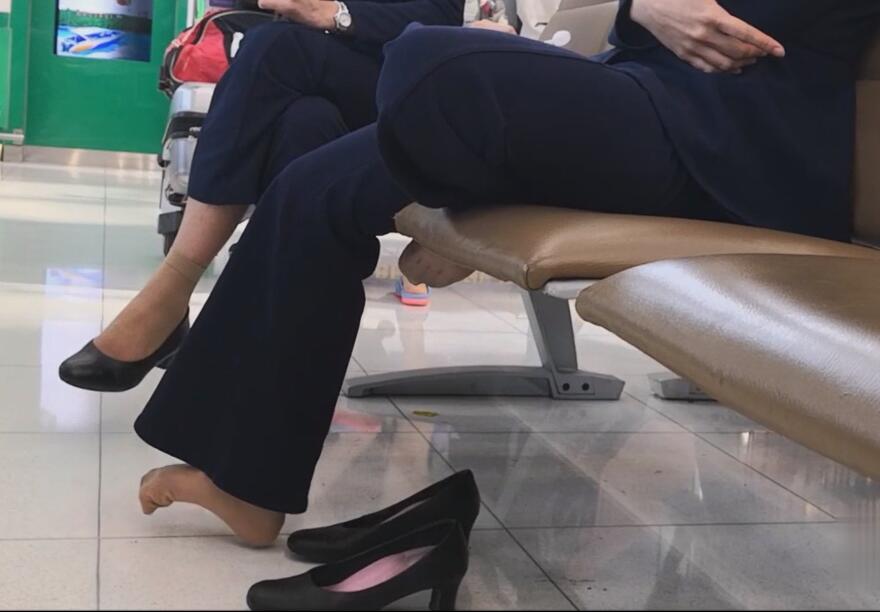 The air hostess dangling shoeplay In the terminal lounge