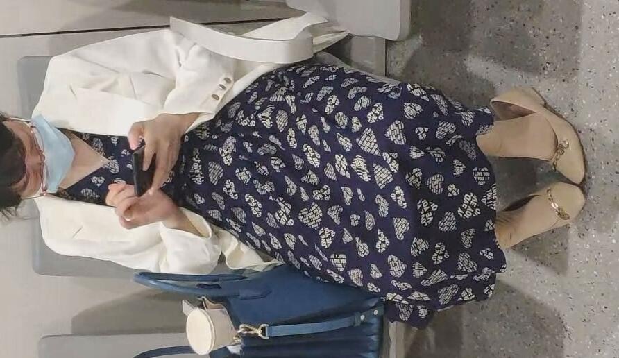 The lady in white nylon dangling shoeplay when playing cell-phone